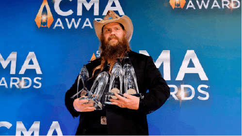 its a ,man holding four CMA award in his hand. 